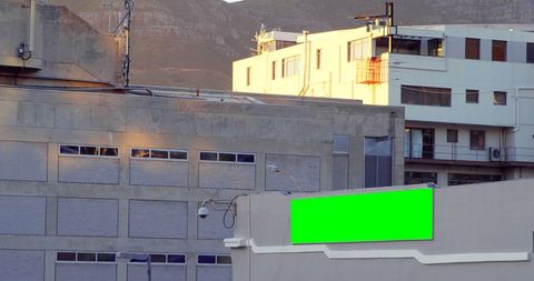 Urban billboard with green screen for advertising in mountainous city