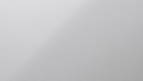 Textured light gray paper surface with fine grain and soft shadows for minimalist backdrop