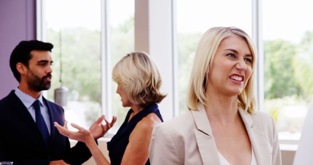 Businesswoman Showing Displeasure with Colleagues in Background - Download Free Stock Images Pikwizard.com