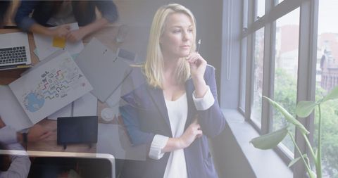Pensive Businesswoman Overlaid on Office Team Meeting and City