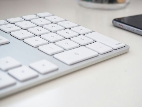 Close-Up of Sleek White Keyboard and Smartphone on Desk