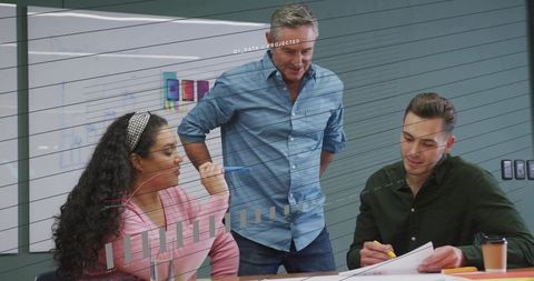 Team reviewing project data and collaborating on strategy in modern office meeting