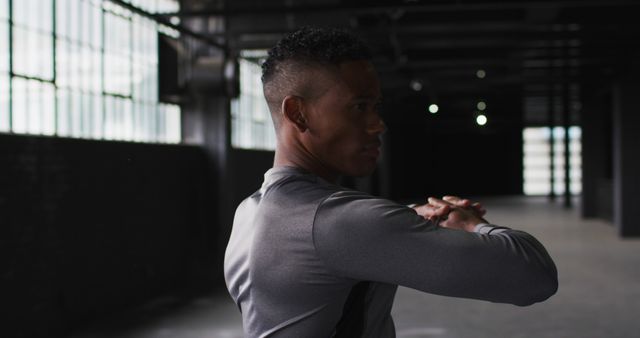 Man Stretching in Industrial Gym Warehouse with Natural Light - Download Free Stock Images Pikwizard.com