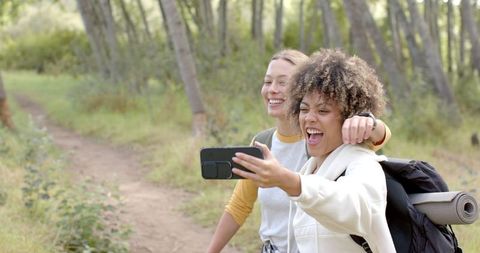 Two Women Hiking and Taking Selfies in Forested Pathway