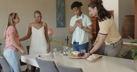 Friends arranging table for meal celebrating togetherness