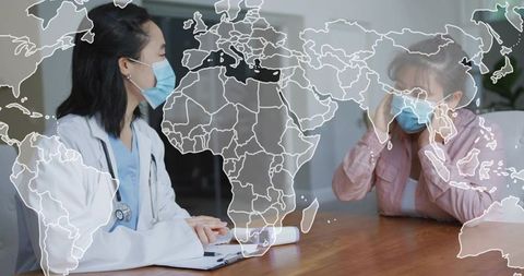 Doctor consulting masked patient with world health map overlay and stethoscope