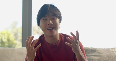 Asian College Student Engaging in Discussion on Couch