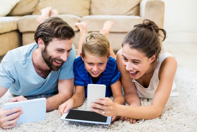 Parents using digital tablet and mobile phone in living room at home