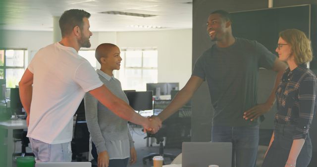 Young biracial business people shaking hands with each other in modern office. Young biracial business people interacting with each other 4k