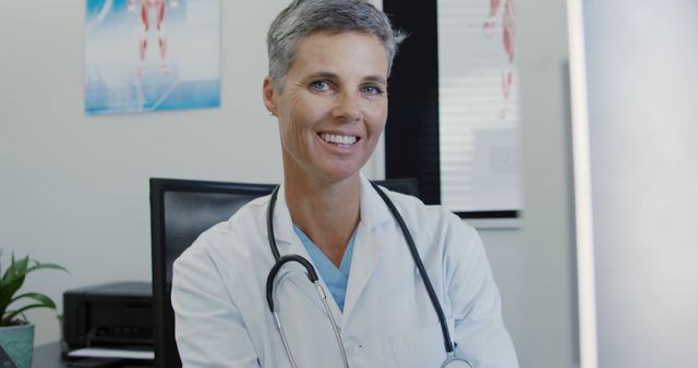 Confident Smiling Doctor in a Medical Office with Stethoscope - Download Free Stock Images Pikwizard.com