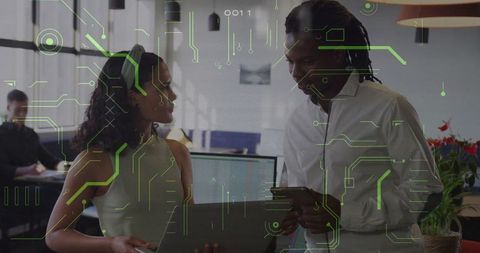 Diverse Coworkers Discussing Technology in Modern Office