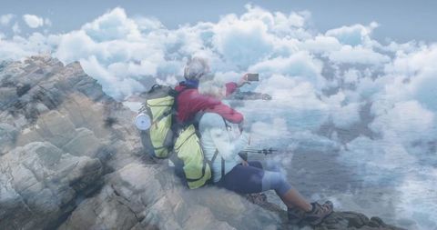 Mature couple on coastal adventure happy hiking and capturing moments with selfie