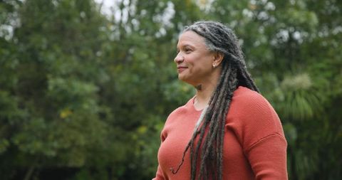 Senior woman with dreadlocks enjoying tranquil garden