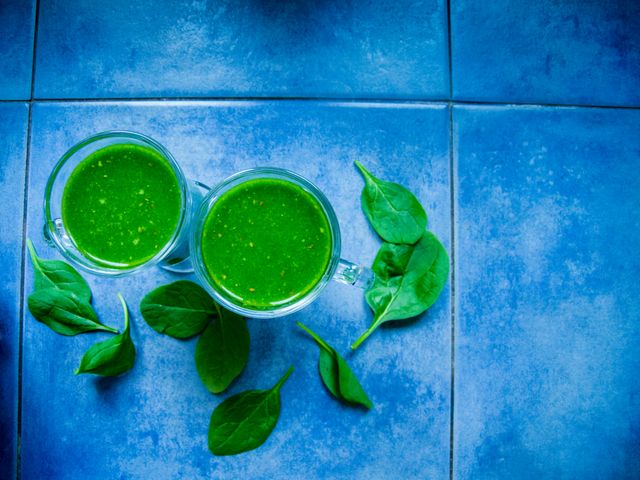 Two Green Smoothies with Fresh Spinach Leaves on Blue Tiles - Download Free Stock Photos Pikwizard.com