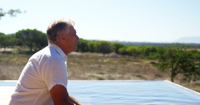 Senior Man Relaxing by Outdoor Pool with Scenic View - Download Free Stock Images Pikwizard.com