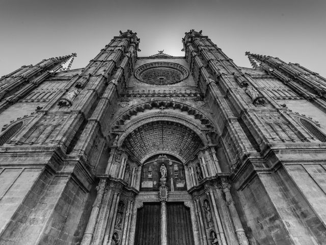 Beautiful black and white capture of a historic cathedral's grand entrance with intricate architectural details in gothic style. This stock image is great for projects involving historical landmarks, heritage sites, architecture studies, travel promotions, religious articles, and educational materials.
