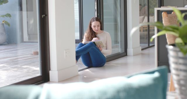 Young Woman Relaxing at Home Reading a Book on the Floor by Windows - Download Free Stock Images Pikwizard.com