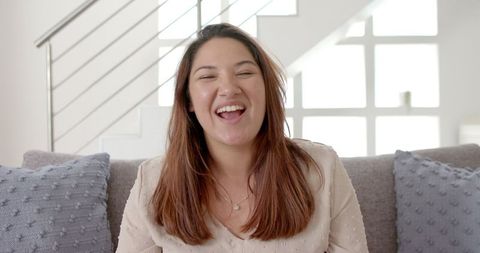 Smiling Young Woman on Video Call in Cozy Living Room