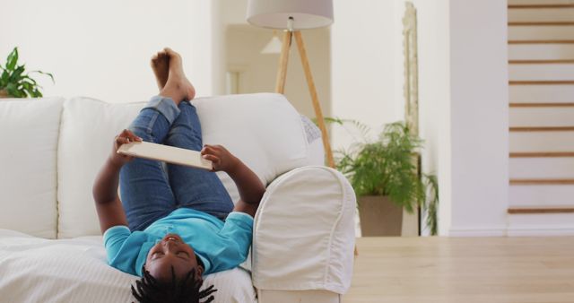 Boy Relaxing with Tablet on Comfortable Couch at Home - Download Free Stock Images Pikwizard.com