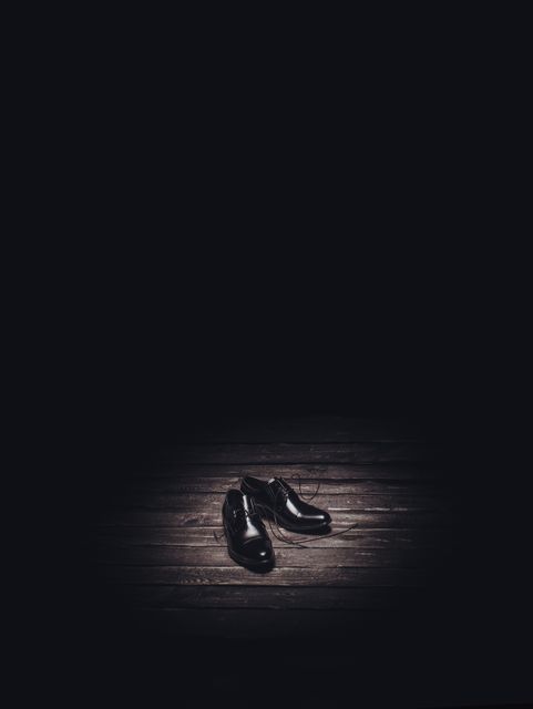 Pair of Leather Dress Shoes on Wooden Floor in Spotlit Dark Room - Download Free Stock Photos Pikwizard.com