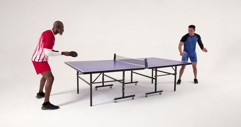 Diverse Male Opponents Engaged in Intense Table Tennis Match