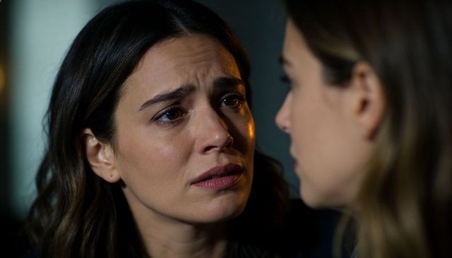 Intimate moment of woman receiving comfort while crying, emotional support close-up, moody light