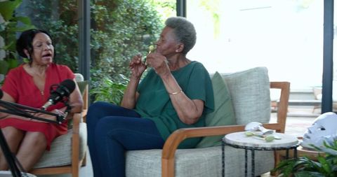 Senior african women hosting podcast and sharing stories in sunlit living room