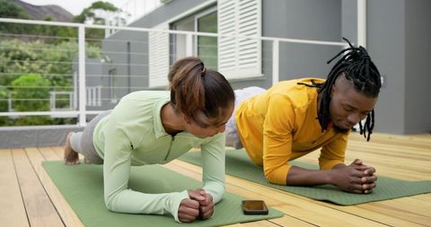 Diverse Couple Practicing Forearm Planks on Deck Mats Outdoor Fitness Core Training