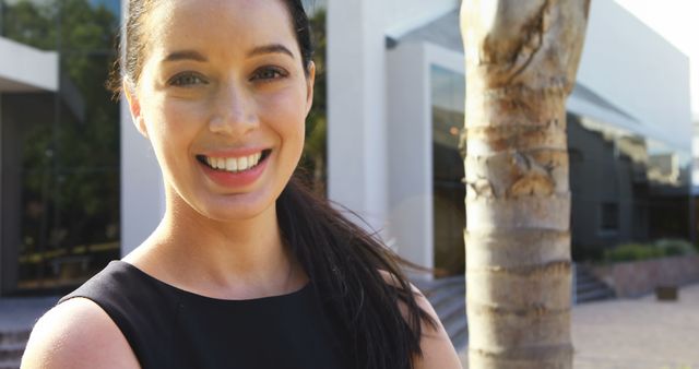 Smiling Woman in Black Dress Outside Modern Building - Download Free Stock Images Pikwizard.com