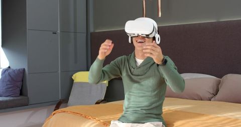 Young man experiencing virtual reality adventure in cozy bedroom