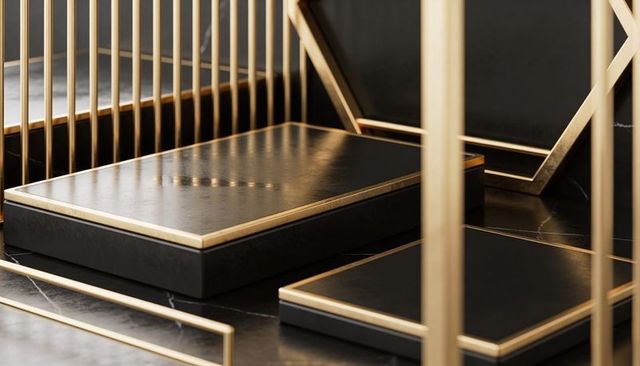 Black onyx pedestal with gold trim and geometric brass frame for luxury product display