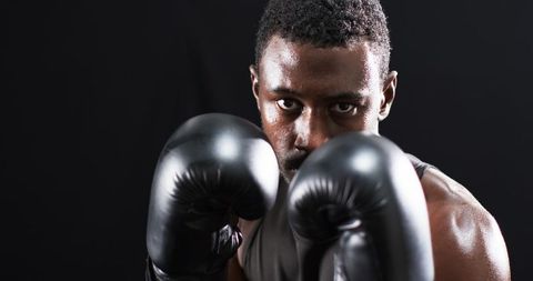 Focused Boxer Preparing Intensely for Fight in Studio