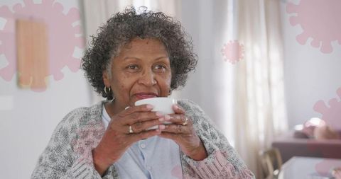 Senior Woman Enjoying Warm Drink Amid Viruses