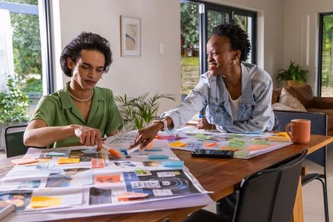 Diverse coworkers collaborating over layout planning and brainstorming at modern workspace
