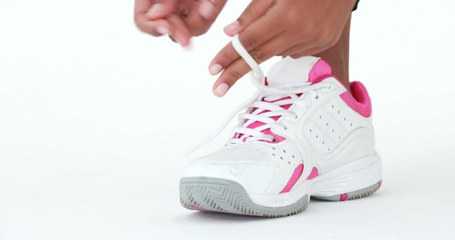 Person Tying White and Pink Sports Shoes on White Background - Download Free Stock Images Pikwizard.com