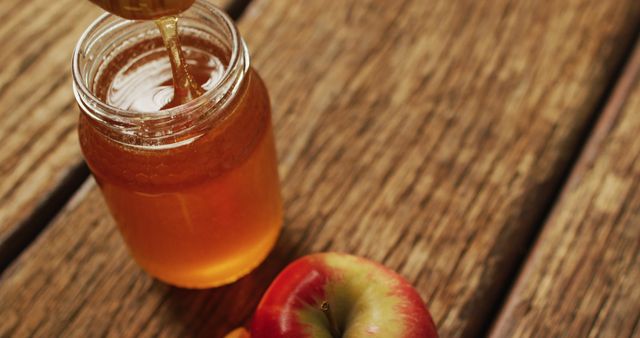 Fresh Honey Pouring into Jar with Crisp Apple on Wooden Surface - Download Free Stock Photos Pikwizard.com