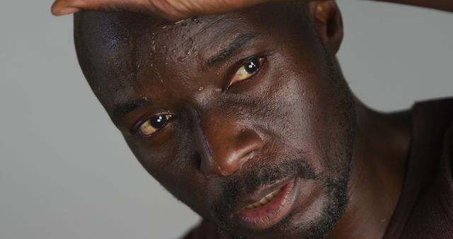 Portrait of sweaty fit african american man exercising inside gym. cross training for fitness in gym.