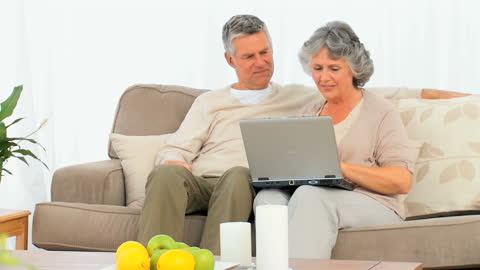Senior Couple Comfortable at Home with Laptop