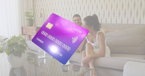 Purple contactless credit card floating over couple relaxing on living room sofa