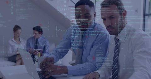 Business professionals collaborating over laptop with code overlay for software development