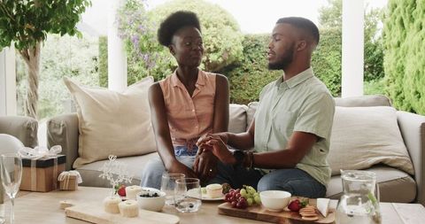 Couple Enjoying Intimate Moment on Patio with Fruits and Desserts