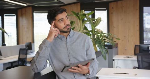 Professional Contemplating New Idea in Modern Office with Tablet
