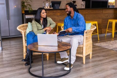 Diverse coworkers collaborating and discussing project in modern cozy communal lounge
