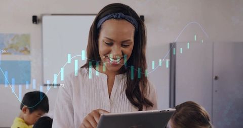 Teacher using tablet teaching interactive lessons with digital chart overlay in classroom