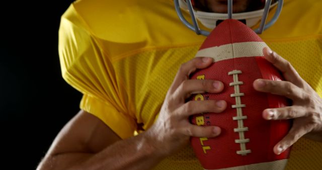 Football Player Holding Ball in Yellow Uniform, Close-Up - Download Free Stock Images Pikwizard.com