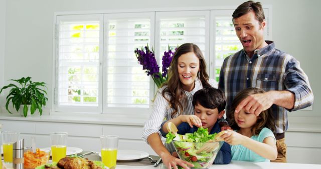 Family bonding over meal preparation in a bright, modern kitchen. Perfect for promoting healthy eating, family time, home lifestyle, kitchen products, and family-oriented campaigns.