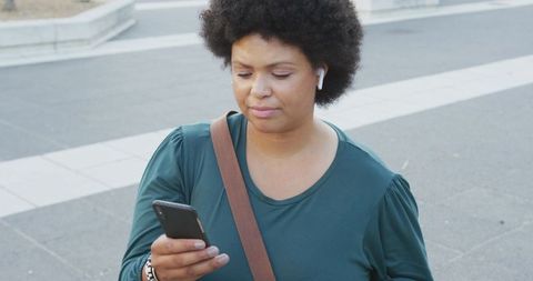Confident plus size woman using smartphone outdoors