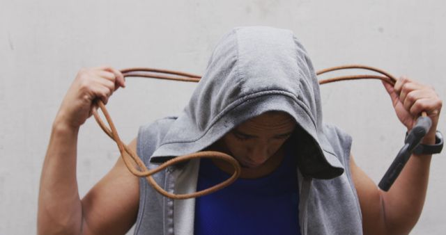 Man in Hoodie Holding Jump Rope Focused on Workout Preparation - Download Free Stock Images Pikwizard.com