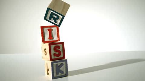Toppling Wooden Blocks with Risk Spelled Out Concept