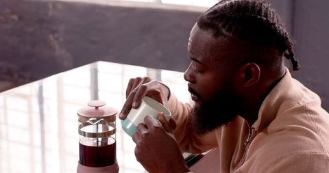 Man savoring coffee break with french press in modern office
